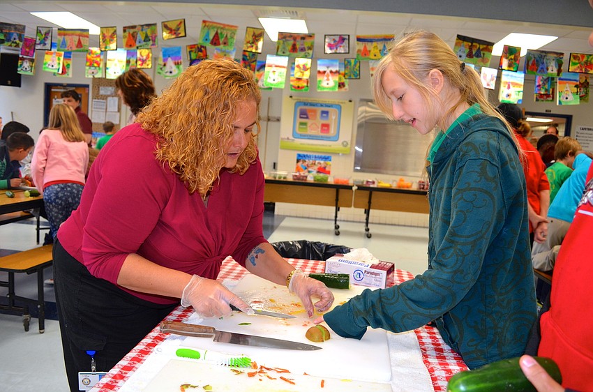 Rozalyn Charette,of the county's Food Service Department, works with Olivia Henderson to chop fruit and vegetables.