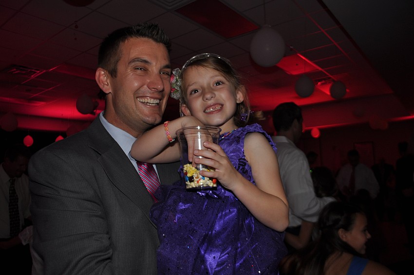 Kevin Gurski dances with his daughter, Ryann, as she chomps on popcorn.