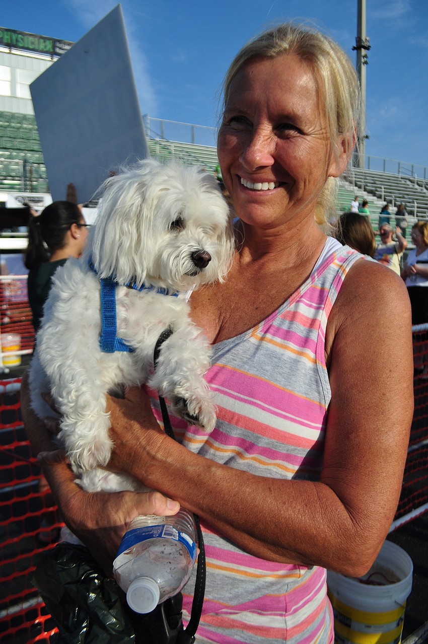 Chris Walker and her dog, Mozart, cheer on friends.
