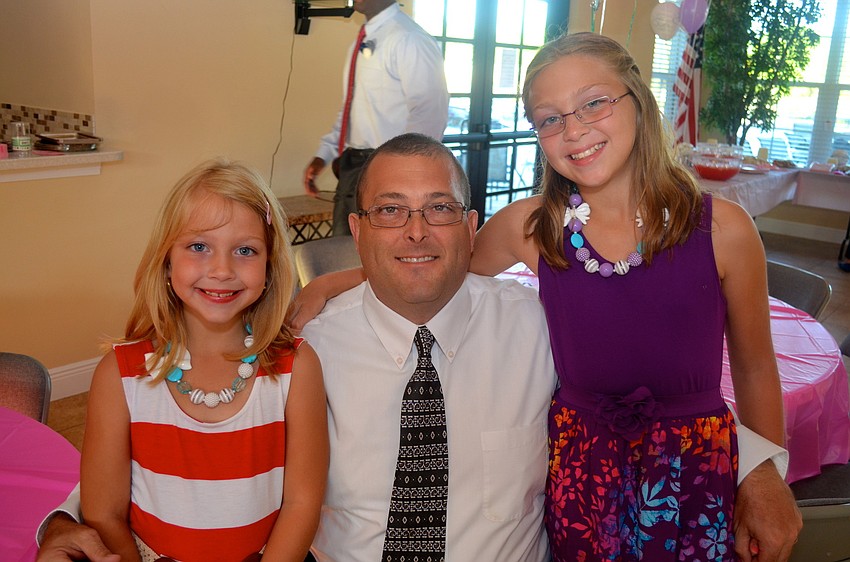 Kalli Bryan shows off her stripped dress, beside her father, Andrew, and her sister, Kassi.