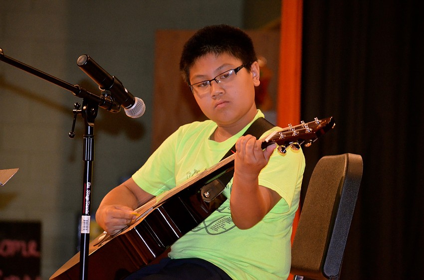 Eleven-year-old Kaiman Carreon plays his guitar.