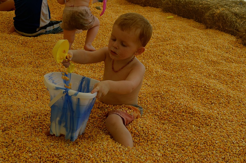Two-year-old Xavier Strickland takes a corn bath.