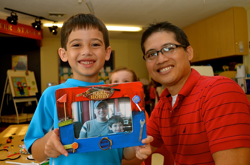 Caden Bianes shows off a decorated picture frame he crafted for his father, Anthony.