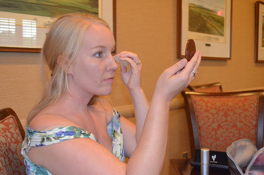 Kelsey Yantzer puts the finishing touches on her face.