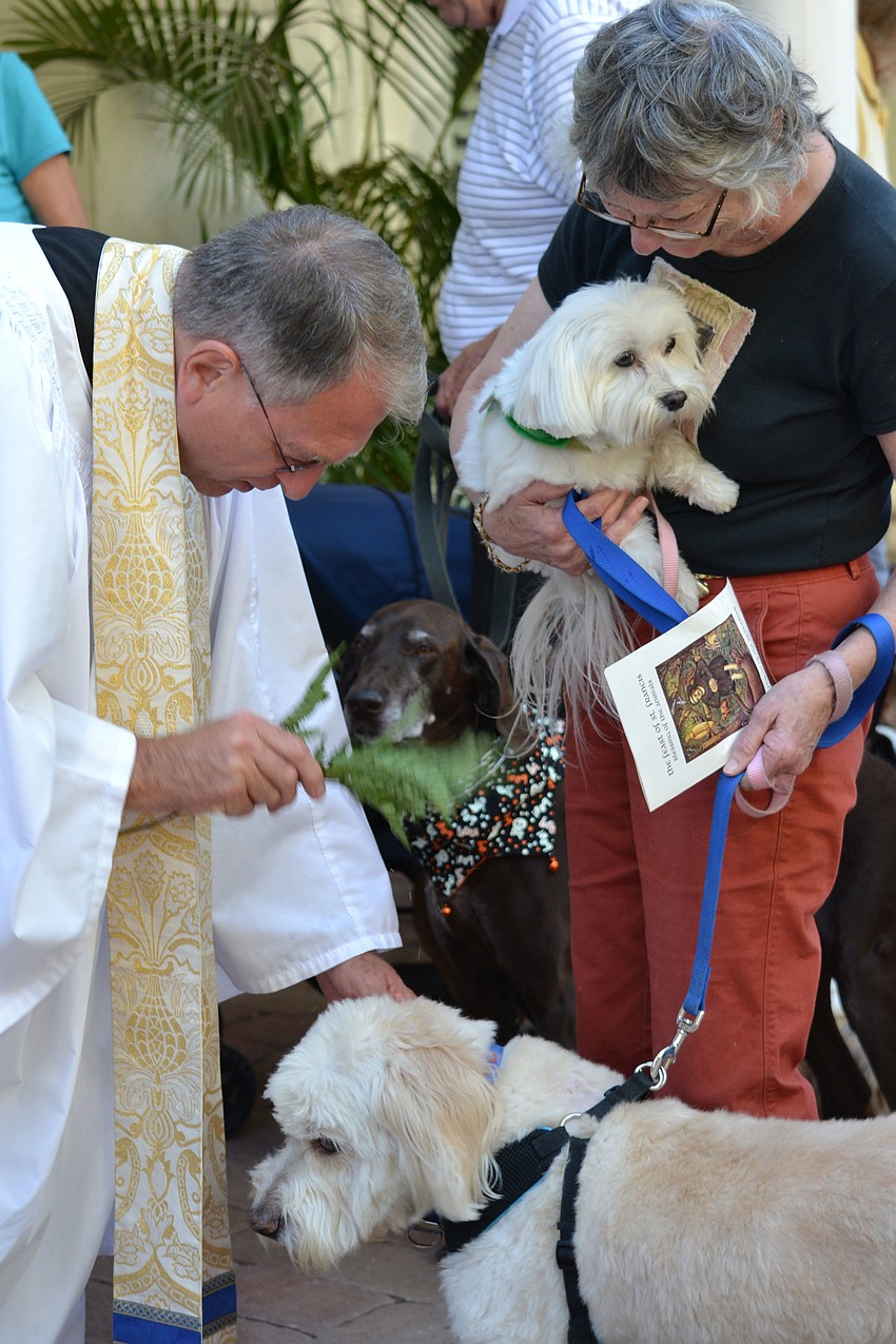 Rev. Fredrick Robinson, Rector blesses Benji while Stella Mason holds Mae.