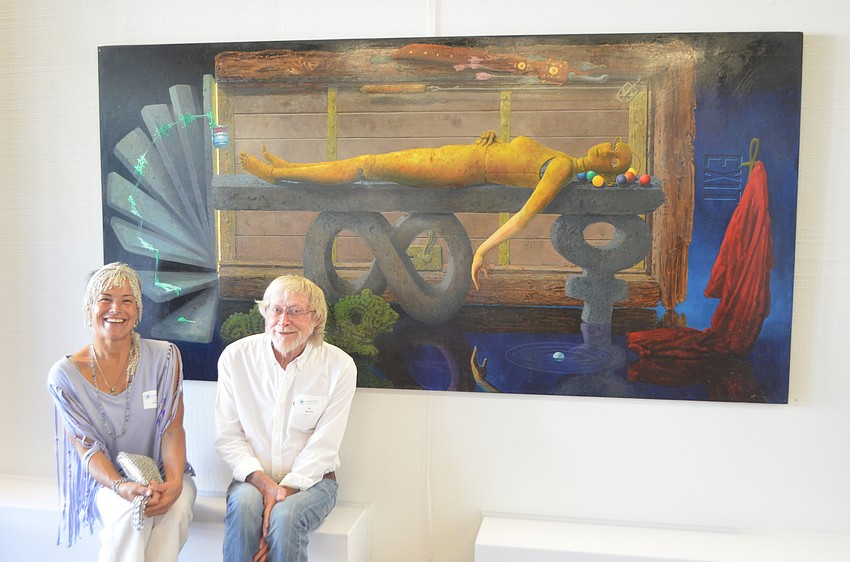 Ed Miracle and partner Tree Beesong pose in front of Miracleâ€™s painting â€œEmma.â€