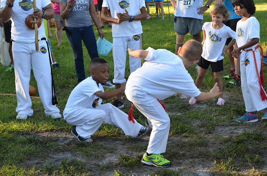 Selah Satchell crouches down during a Capoeira presentation.
