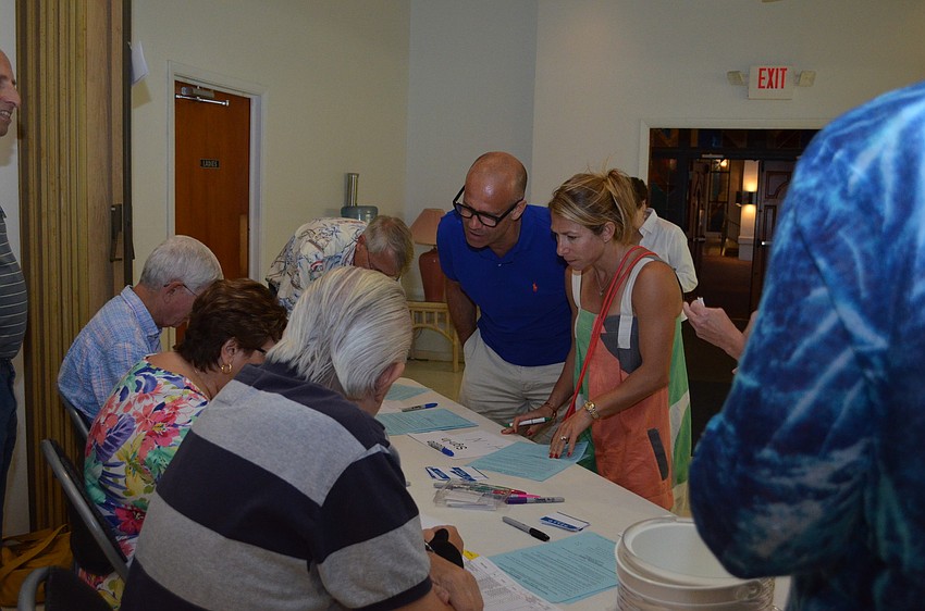 Members of the Siesta Isles Association sign in and grab some snacks before the meeting starts.