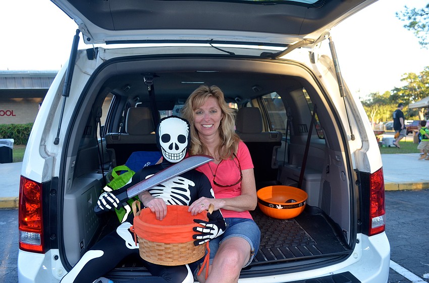 Charles Suarez and his mother, Marcie, distribute candy from their family vehicle.