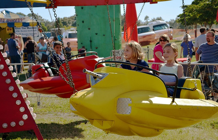 Zoe Selby and Avalon Selby take a spin on a carnival ride at the Sarasota Pumpkin Festival.