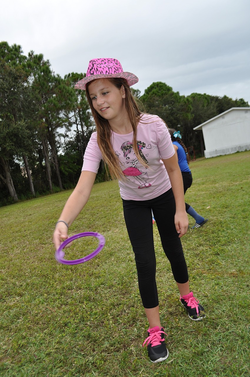 Makenna Stennett, a Braden River Middle School student, tries her hand at the ring toss.