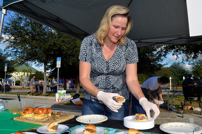 Jennifer Palladino displays the burgers grilled at the Jamakin Me Crazy booth.