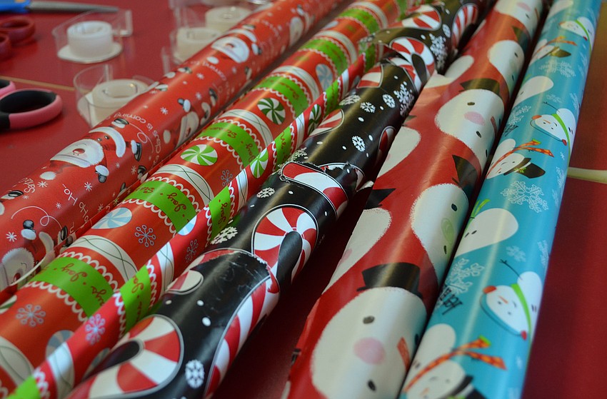 YPG members split up into groups to wrap gifts with an assortment of holiday-themed wrapping paper.