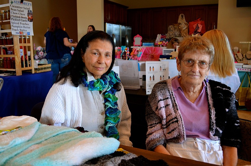 Ruth Goldwyn and Bea Walker show off handmade clothing items Walker crafted.