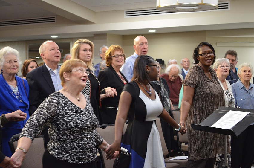 Guests in attendance joined hands in singing â€œReach Out and Touch Someone.â€