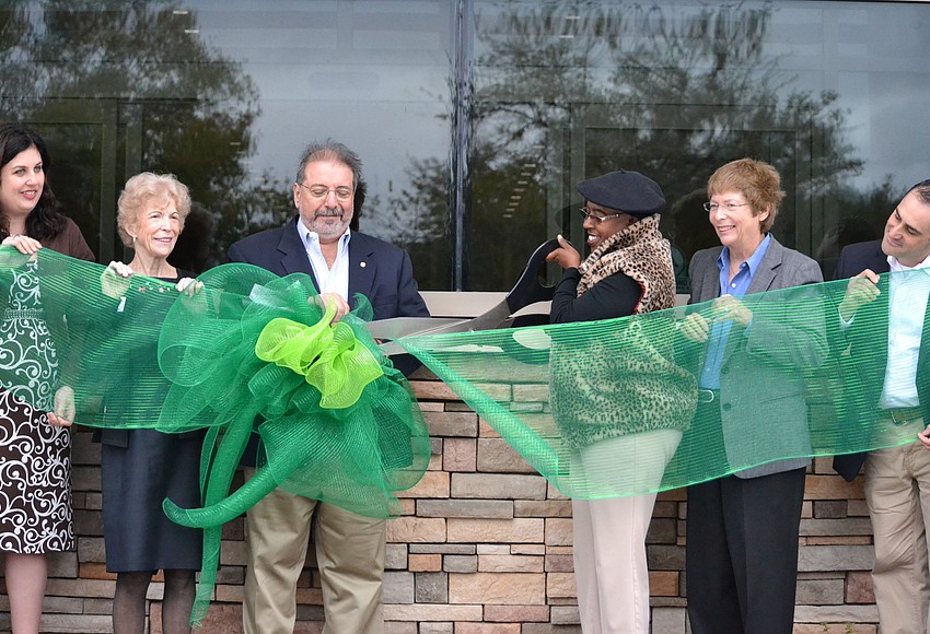 Your Observer Photo Commissioner Carolyn Mason cuts the ribbon to