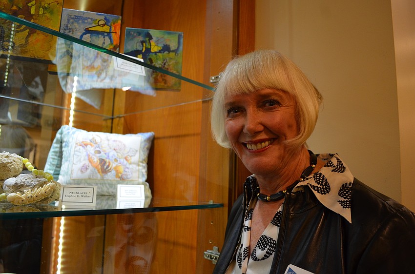 Exhibitor Anita Pihl in front of her needlepoint pillow
