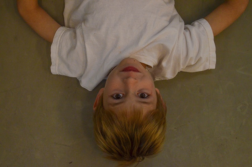 Seven-year-old Wilhelm Cockrell interrupts stretching because he wants a photo taken of him.