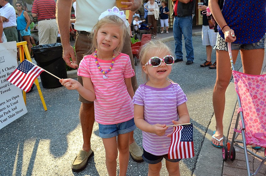 Baya and Jovie Enoin wave their American flags.