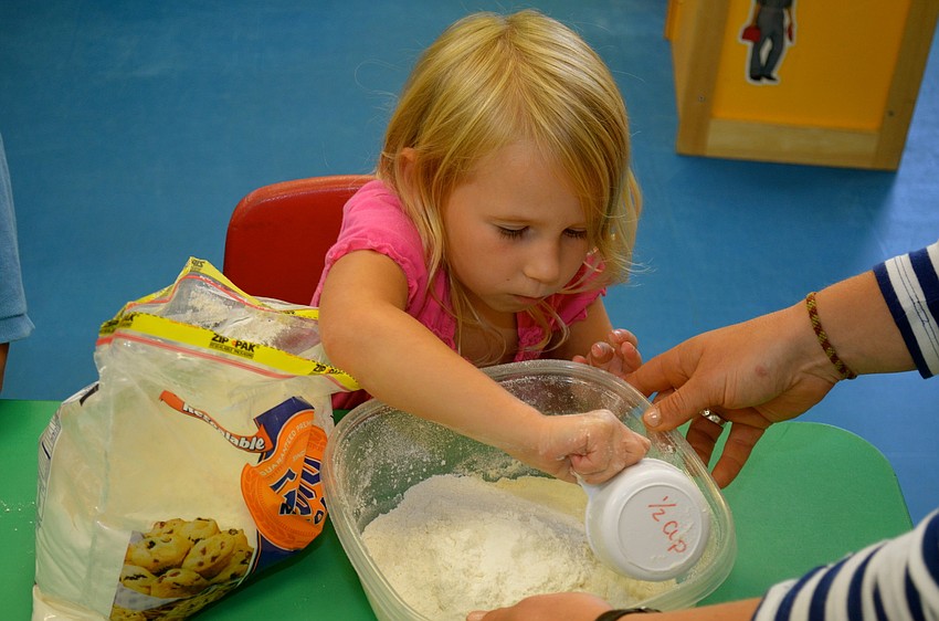 Dakota Manns scoops flour.