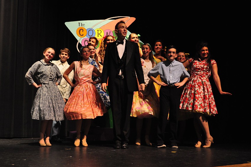 Council members dance around Corny Collins, played by Joseph Grosso, as he greets television viewers.