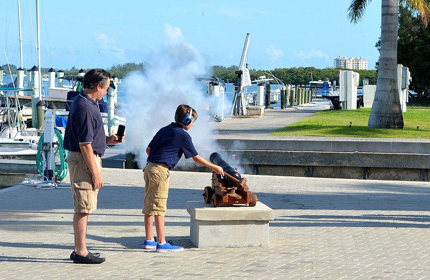Brian Hutson and his son, Christian, light the canon during the Sundowner Ceremony.