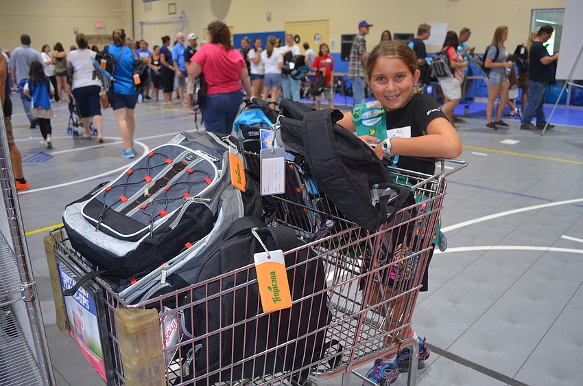 Larissa Lippe helps cart away filled backpacks.