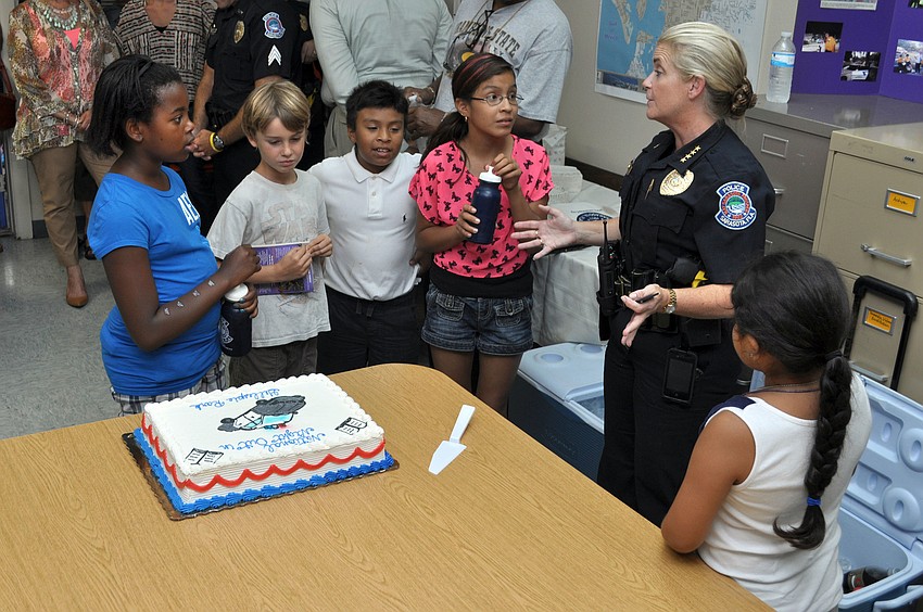 Chief of Police Bernadette DiPino talks to the children at National Night Out Against Crime about important safety precautions and deputizes them as Sarasota Police Junior Officers.
