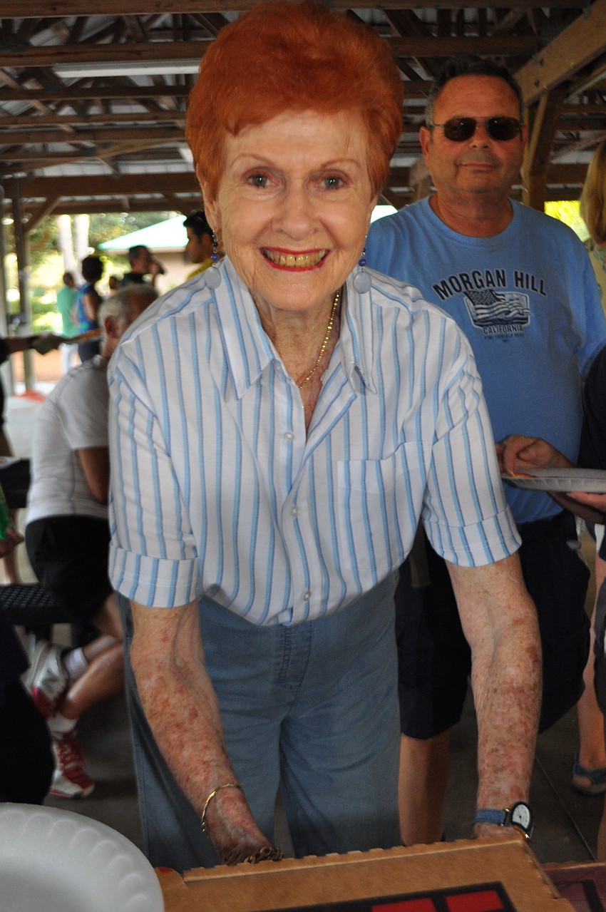 Summerfield resident Phyllis Troy assists with pizza distribution.