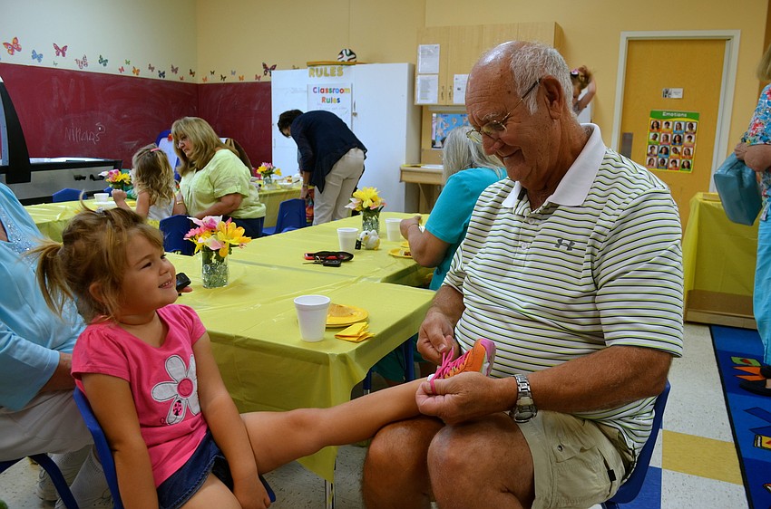 Payton Gross listens as her grandpa, Don Gross, explains how to tie shoelaces.