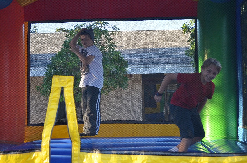 James Hodges and Matthew Wolf jump around in the bounce house at the