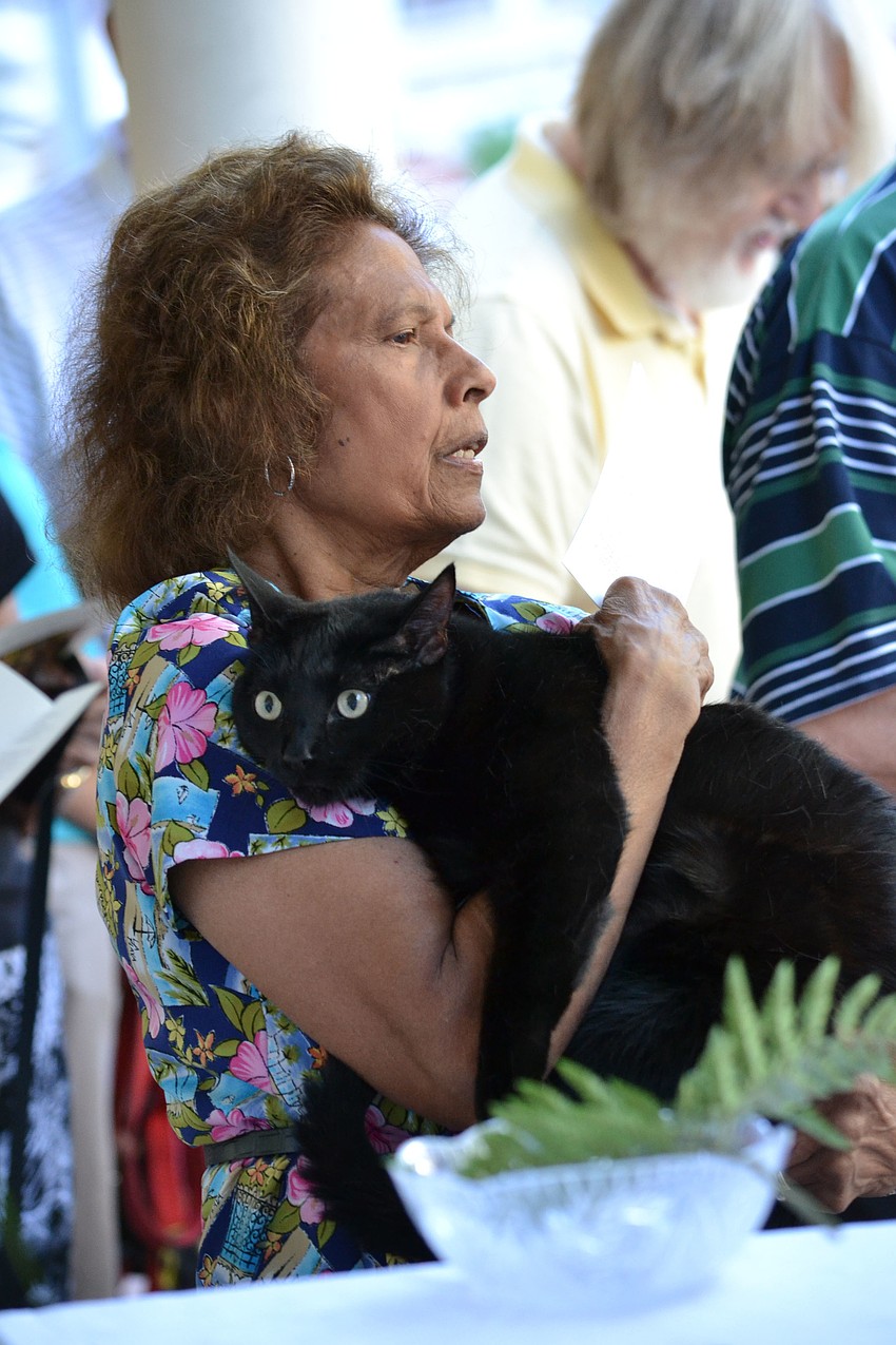 Batie Thomas holds her cat Lennox during during prayer at the Blessing of the Animals.