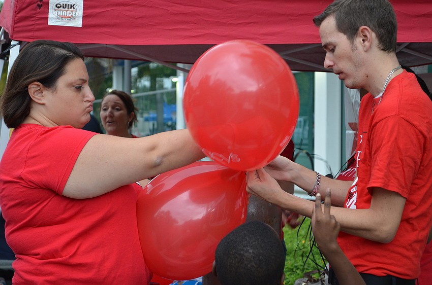 Ashley Piccirillo and RJ Smith of Macyâ€™s inflate balloons to hand out to children at the event.