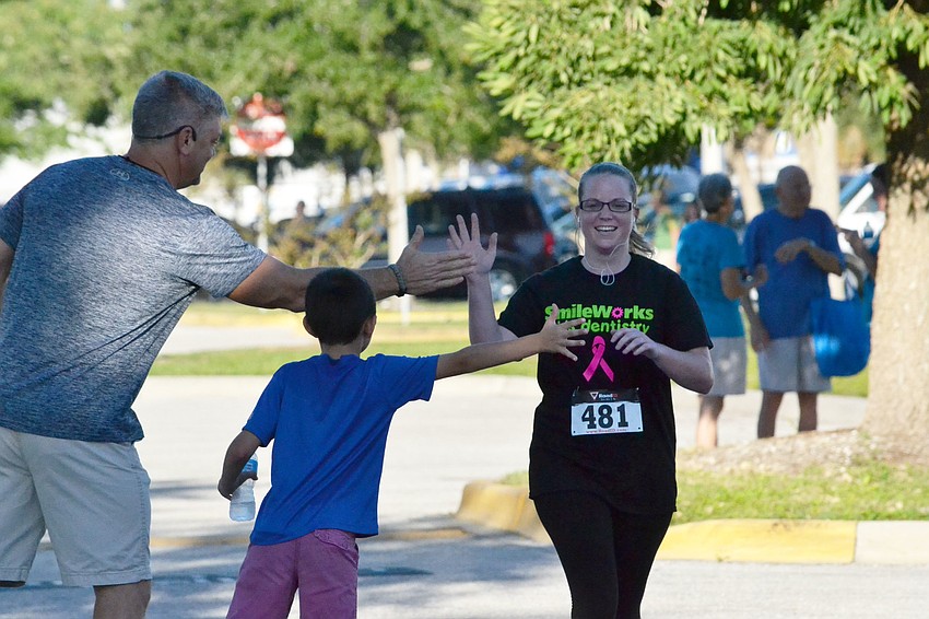 Audra Snow gives a high-five as she crosses the finish line.