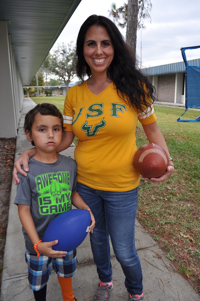 McNeal Elementary's Talan Rich helps his mom, Tara first-grade teacher Debbie Rich, with a football toss game.