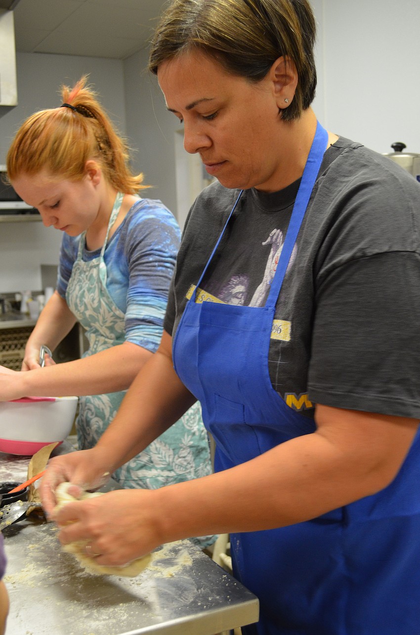 Amy Meese kneads the challah dough.