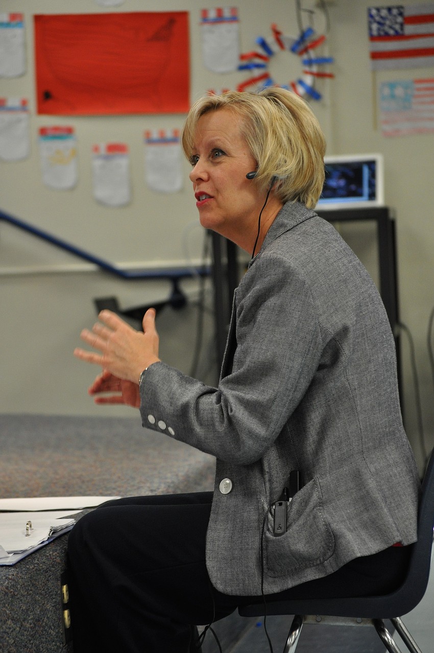 Music teacher Barbara Sullivan directs students.