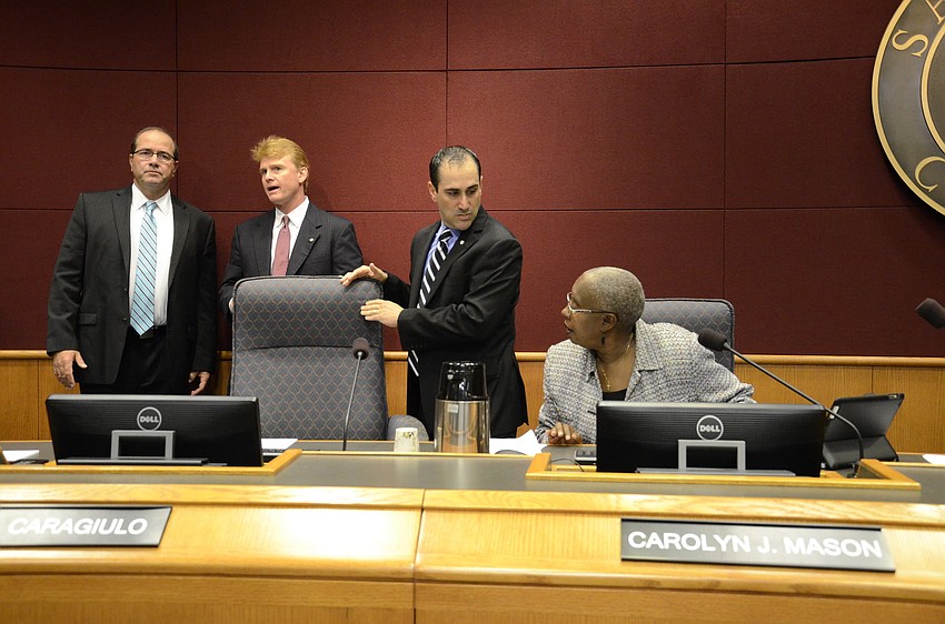 County Administrator Tom Harmer and Commissioners Charles Hines and Carolyn Mason talk with new Commissioner Paul Caragiulo as he prepares to take his seat for his first county commission meeting.