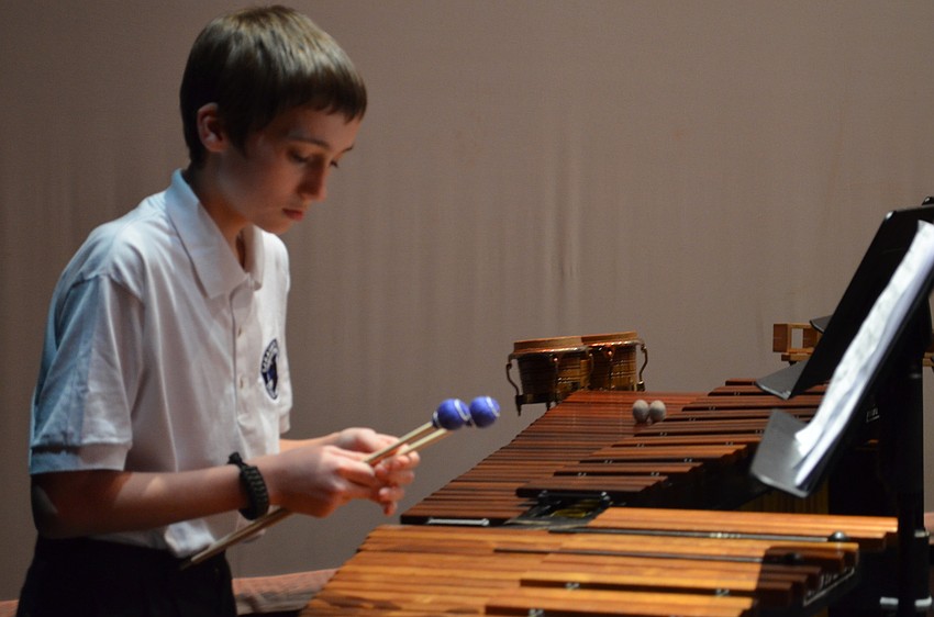 Sarasota Middle School student Daren Reitsma sets up back stage before performing with the RHS wind ensemble.