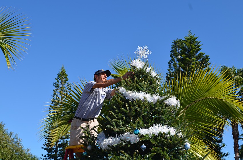 Jim Gottschalk adds the tree topper.