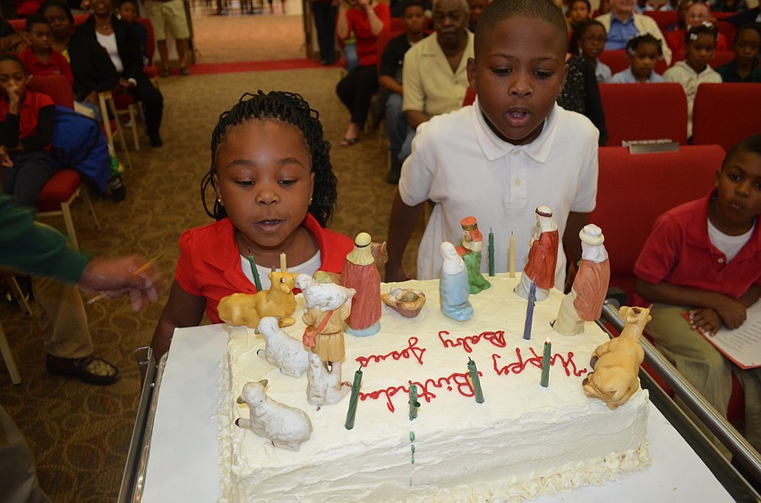 Rihanna Williams and Javon Moss blow out a birthday cake for Jesus.