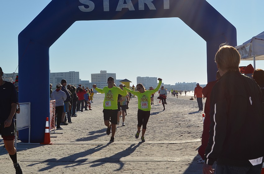 Runners reach the finish line for the Sandy Claws Beach Run 5K.