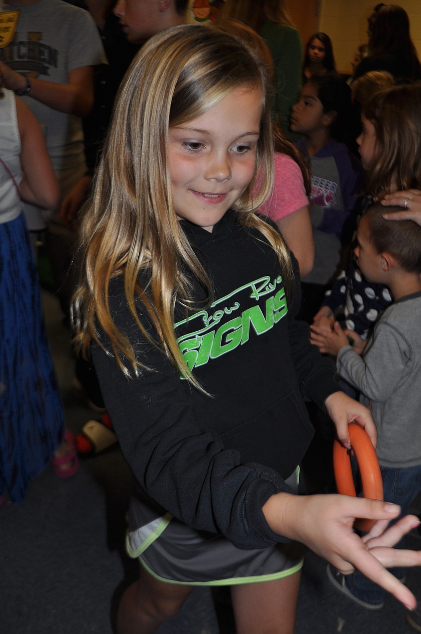 Riana Forcier, 8, tries her hand at the ring toss.
