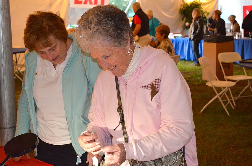 Lois Cormany admires jewelry at the Glamour and Bling booth.