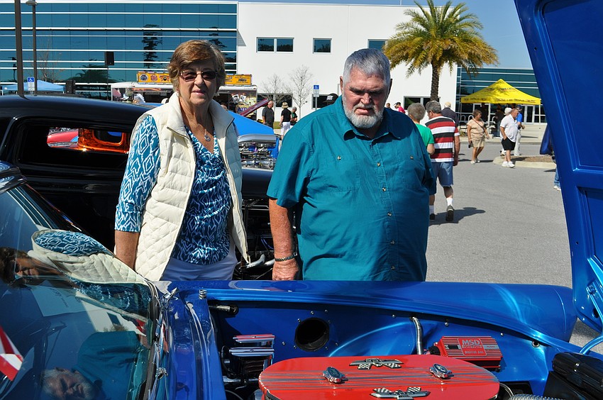 Holly Forward and George McNeff look at Jack Greer's 1957 Ford Thunderbird, which he calls his 