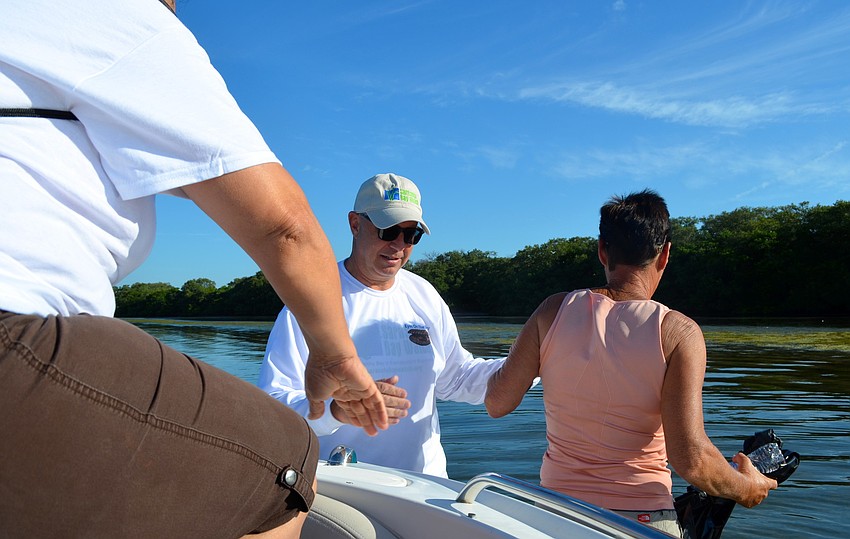 Larry Stults helps Chris Benson off his boat on the south side of Sister Keys.