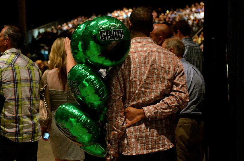 Theo Jean-Pierre waits to hand his girlfriend congratulatory balloons.