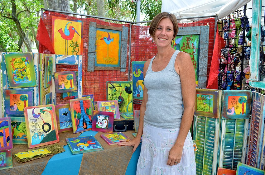 Kelly Burdette smiles in her booth, Kelly B. Designs.