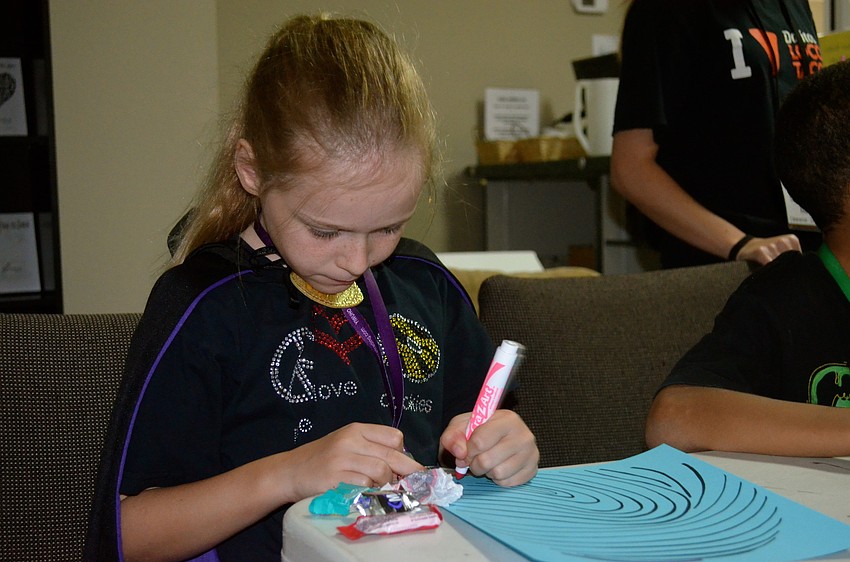Ella Taylor colors her picture.