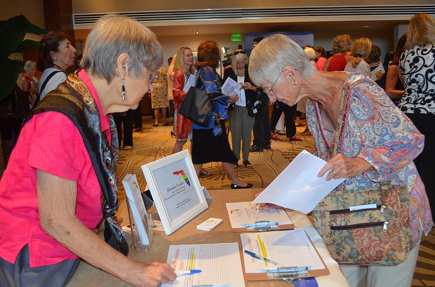 Margaret Newcomer informs Rhana Bazzini of the Manatee County GLBT Allied Democrats.